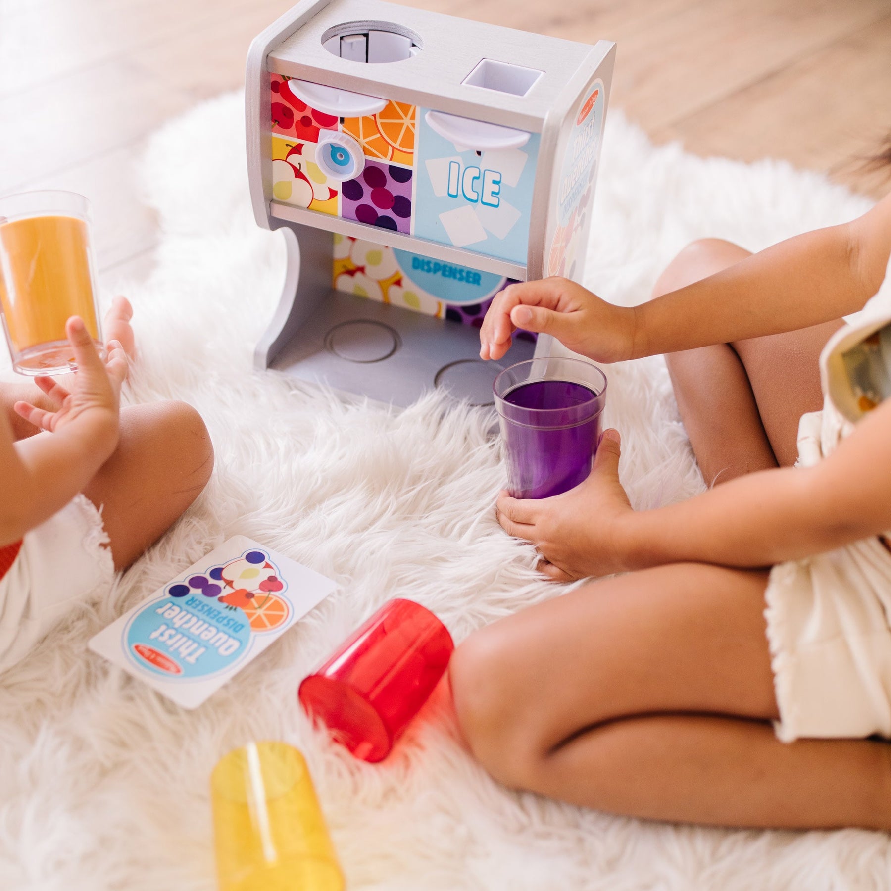 A kid playing with The Melissa & Doug Wooden Thirst Quencher Drink Dispenser With Cups, Juice Inserts, Ice Cubes